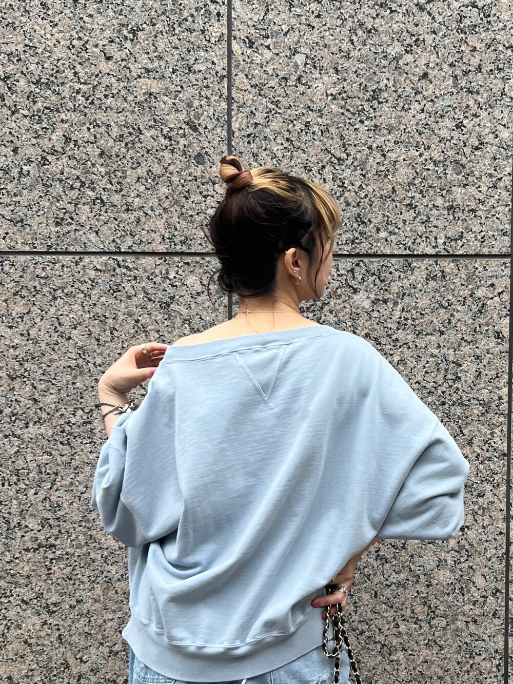 ブルー系のスウェット、ブルー系のデニムパンツ、ブラック系のショルダーバッグを着用したレディースの秋コーディネートの4枚目の写真