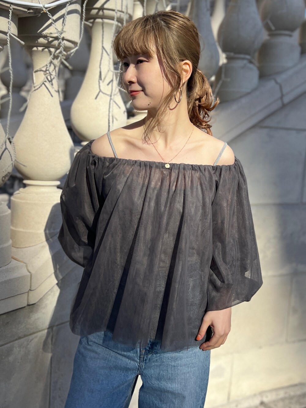 グレー系のシャツ/ブラウス、ブルー系のデニムパンツ、ゴールド系のネックレスを着用したレディースの冬コーディネートの8枚目の写真