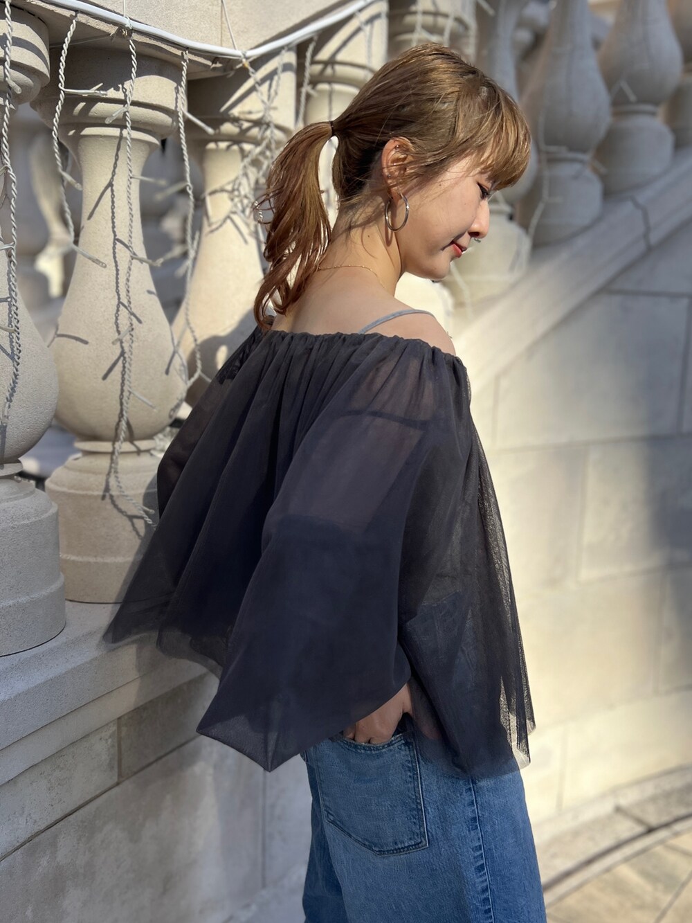 グレー系のシャツ/ブラウス、ブルー系のデニムパンツ、ゴールド系のネックレスを着用したレディースの冬コーディネートの6枚目の写真