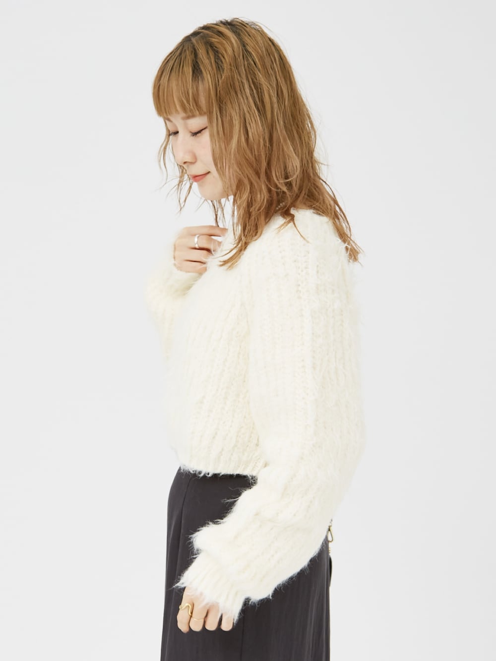 ホワイト系のニット/セーター、ブラック系のパンプス、ブラック系のショルダーバッグを着用したレディースの冬コーディネートの6枚目の写真