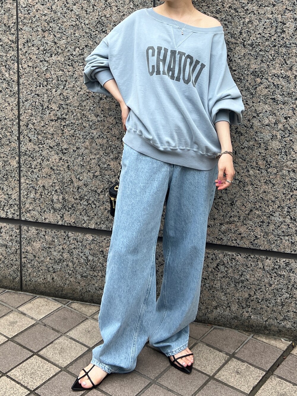 ブルー系のスウェット、ブルー系のデニムパンツ、ブラック系のショルダーバッグを着用したレディースの秋コーディネートの5枚目の写真