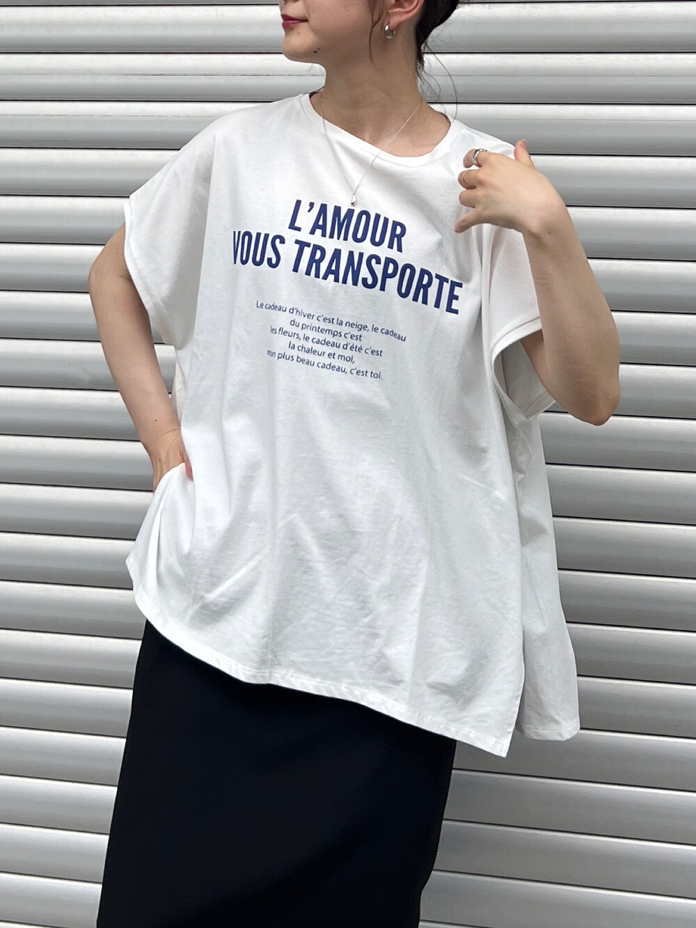 ブルー系のTシャツ/カットソー、ブラック系のスカート、ブラック系のサンダルを着用したレディースの夏コーディネートの4枚目の写真