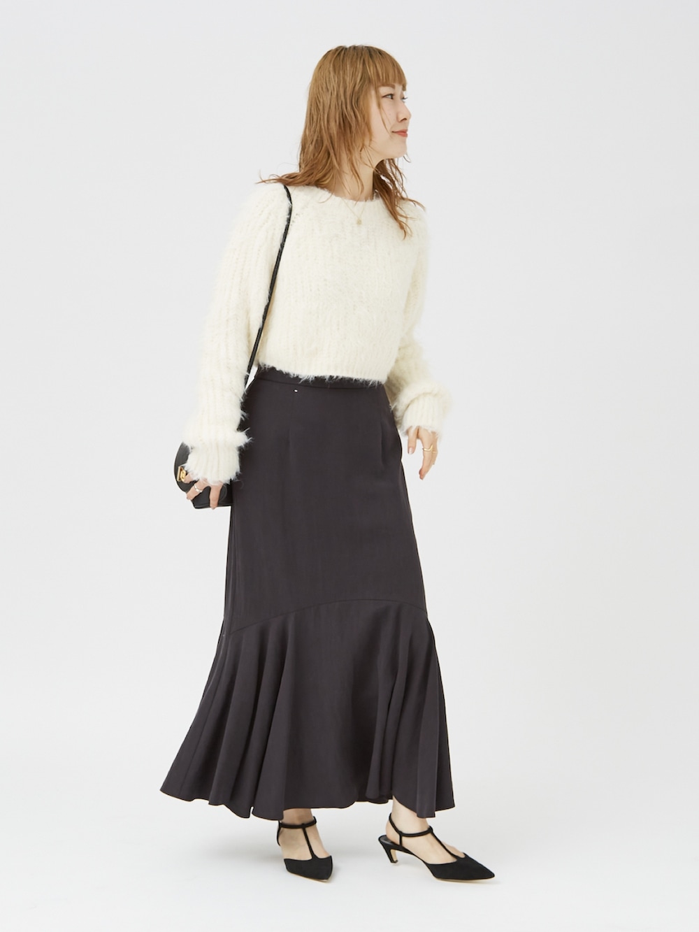 ホワイト系のニット/セーター、ブラック系のパンプス、ブラック系のショルダーバッグを着用したレディースの冬コーディネートの3枚目の写真