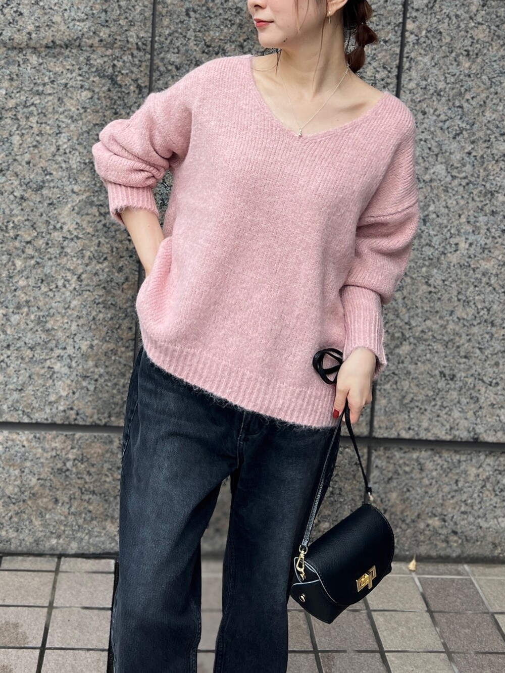 ピンク系のニット/セーター、ベージュ系のセットアップ、ブラック系のショルダーバッグを着用したレディースの秋コーディネートの9枚目の写真