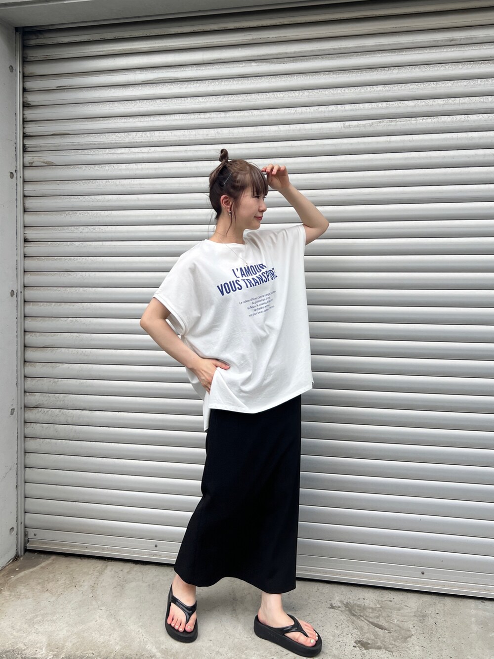 ブルー系のTシャツ/カットソー、ブラック系のスカート、ブラック系のサンダルを着用したレディースの夏コーディネートの3枚目の写真