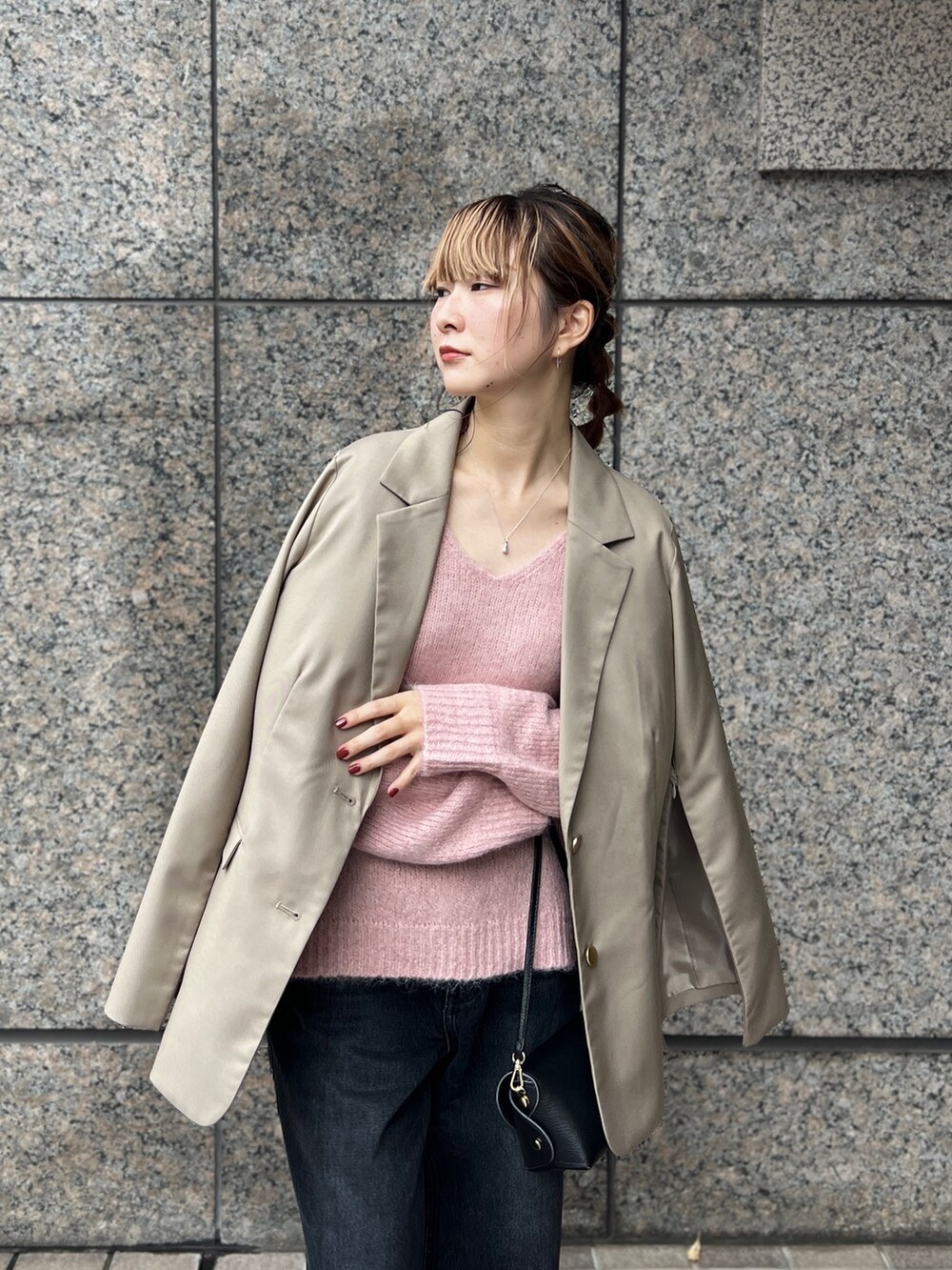 ピンク系のニット/セーター、ベージュ系のセットアップ、ブラック系のショルダーバッグを着用したレディースの秋コーディネートの5枚目の写真