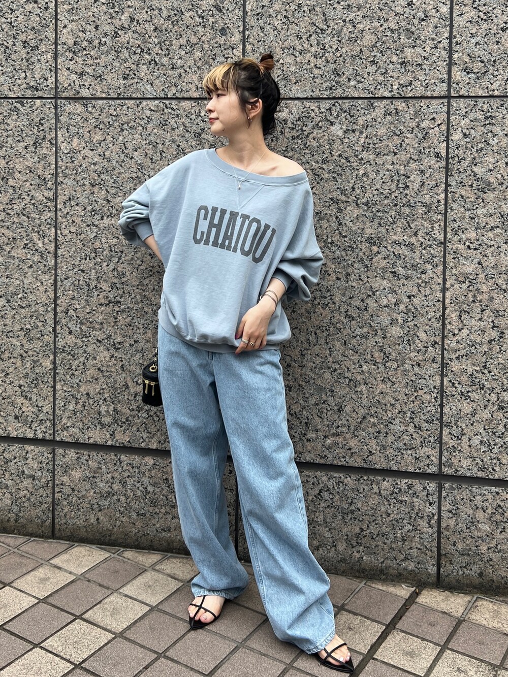 ブルー系のスウェット、ブルー系のデニムパンツ、ブラック系のショルダーバッグを着用したレディースの秋コーディネートの3枚目の写真