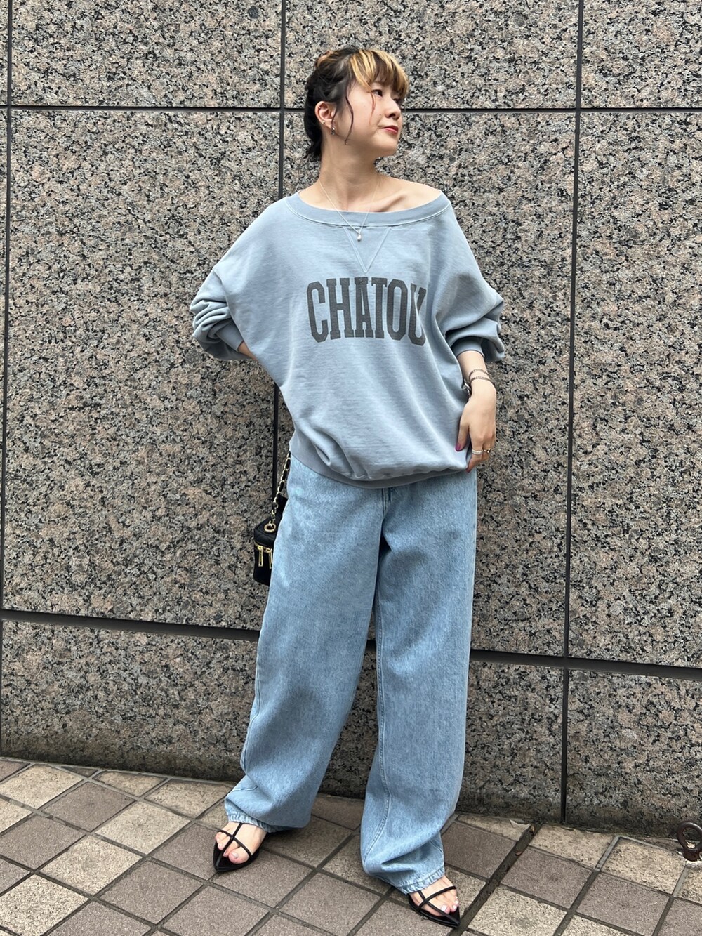 ブルー系のスウェット、ブルー系のデニムパンツ、ブラック系のショルダーバッグを着用したレディースの秋コーディネートの2枚目の写真