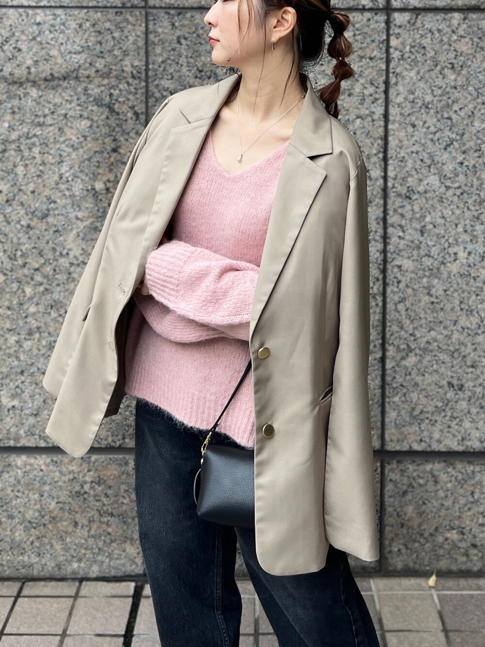 ピンク系のニット/セーター、ベージュ系のセットアップ、ブラック系のショルダーバッグを着用したレディースの秋コーディネートの4枚目の写真