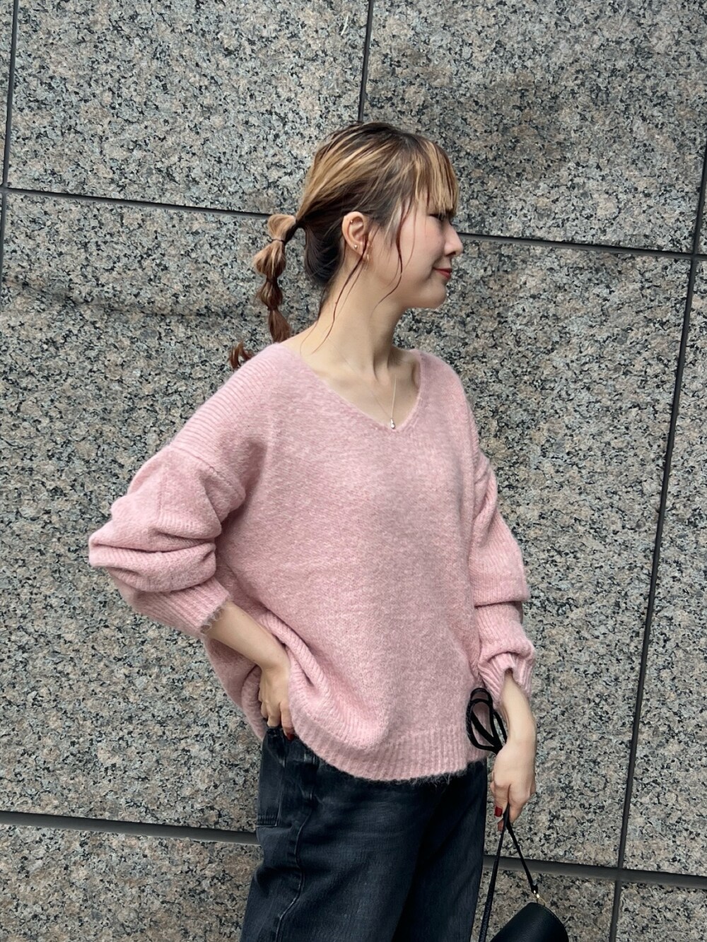 ピンク系のニット/セーター、ベージュ系のセットアップ、ブラック系のショルダーバッグを着用したレディースの秋コーディネートの10枚目の写真