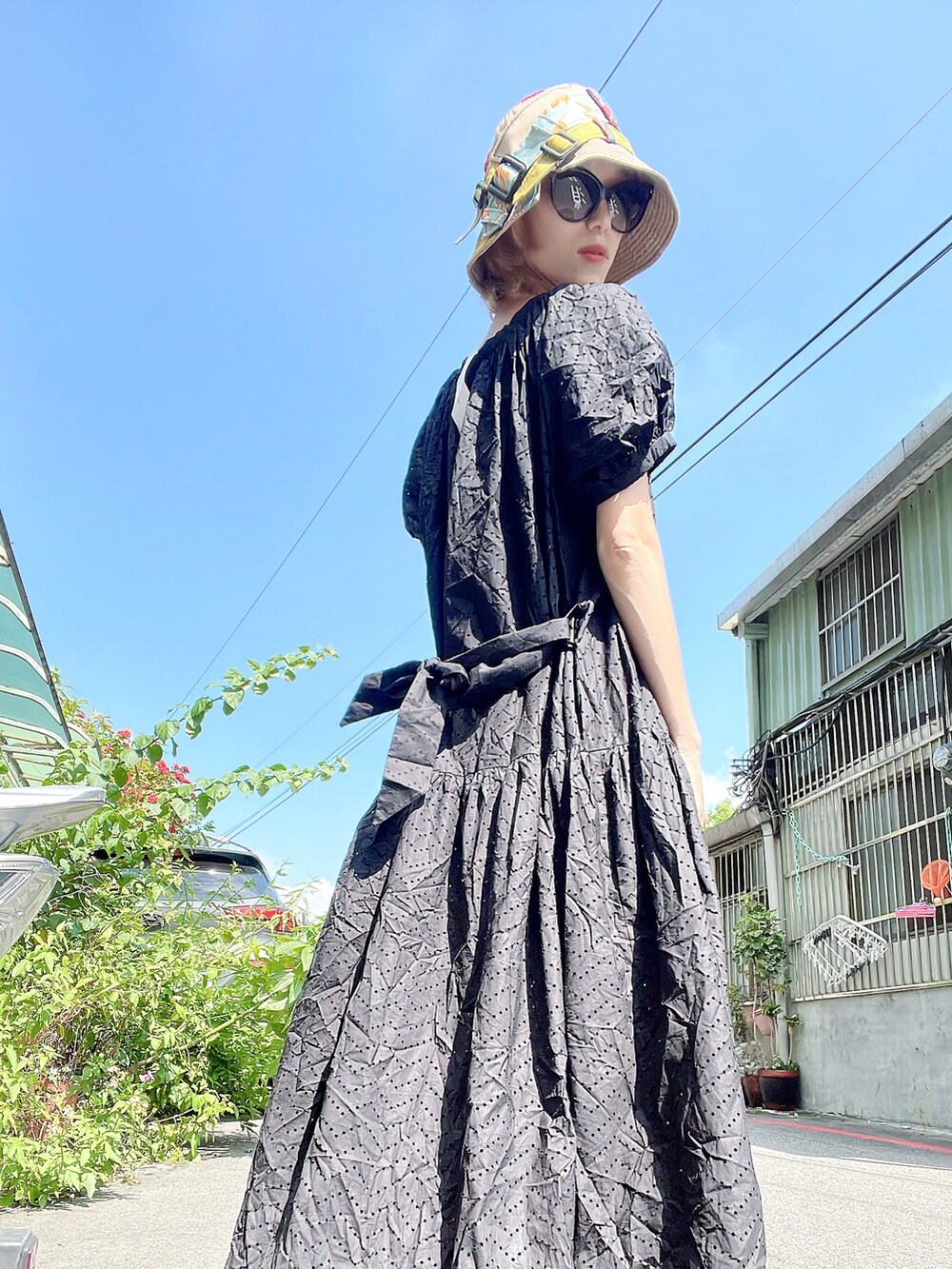 ブラック系のワンピース/ドレス、ベージュ系の帽子、ブラック系のサングラスを着用したレディースの夏コーディネートの3枚目の写真