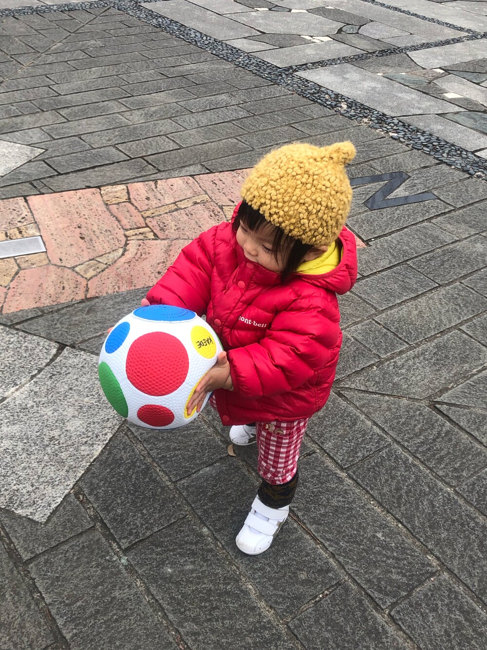 レッド系のダウンジャケット/コート、レッド系のパンツ、ホワイト系のスニーカーを着用したレディースの冬コーディネートの4枚目の写真