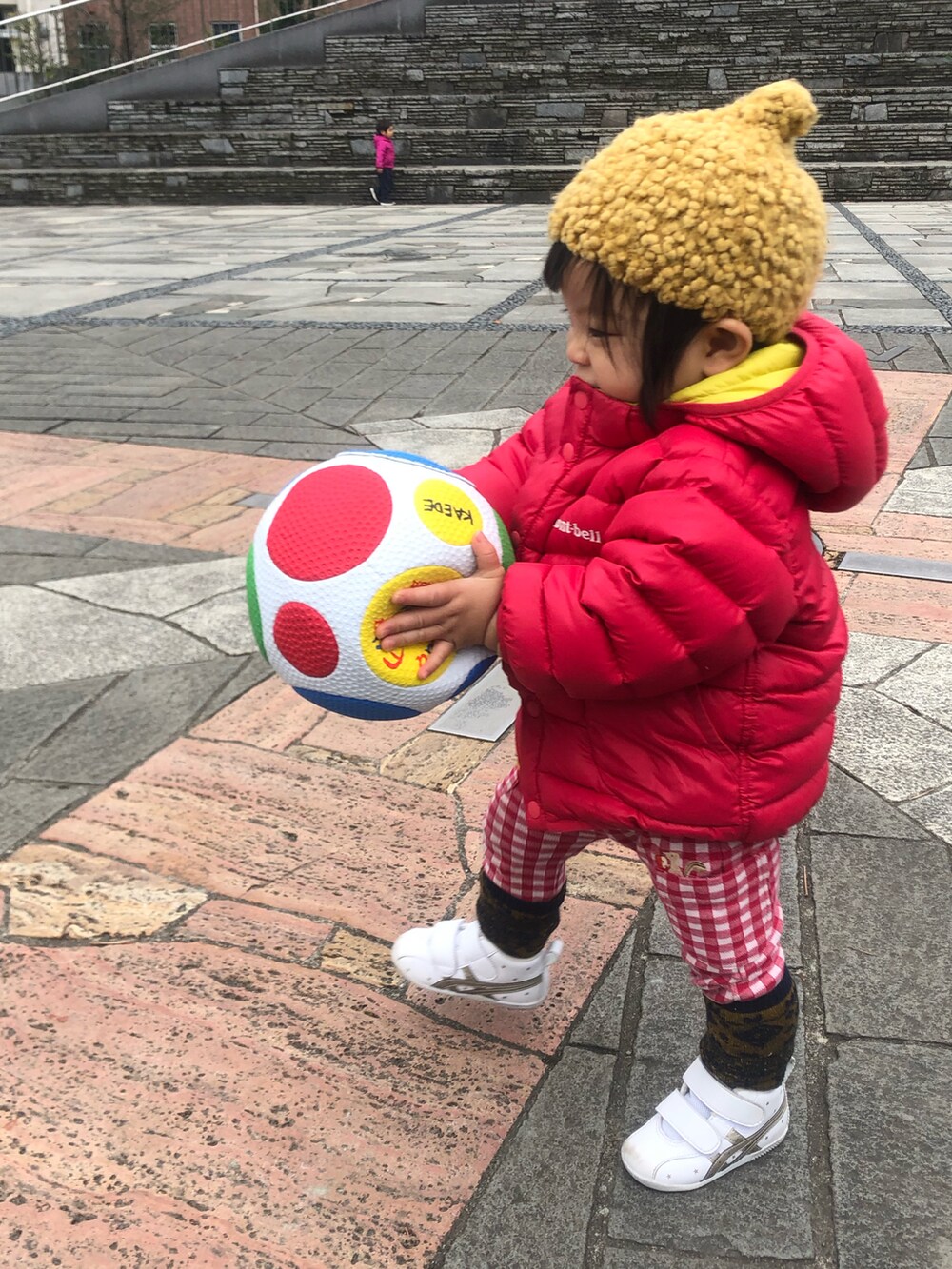 レッド系のダウンジャケット/コート、レッド系のパンツ、ホワイト系のスニーカーを着用したレディースの冬コーディネートの2枚目の写真