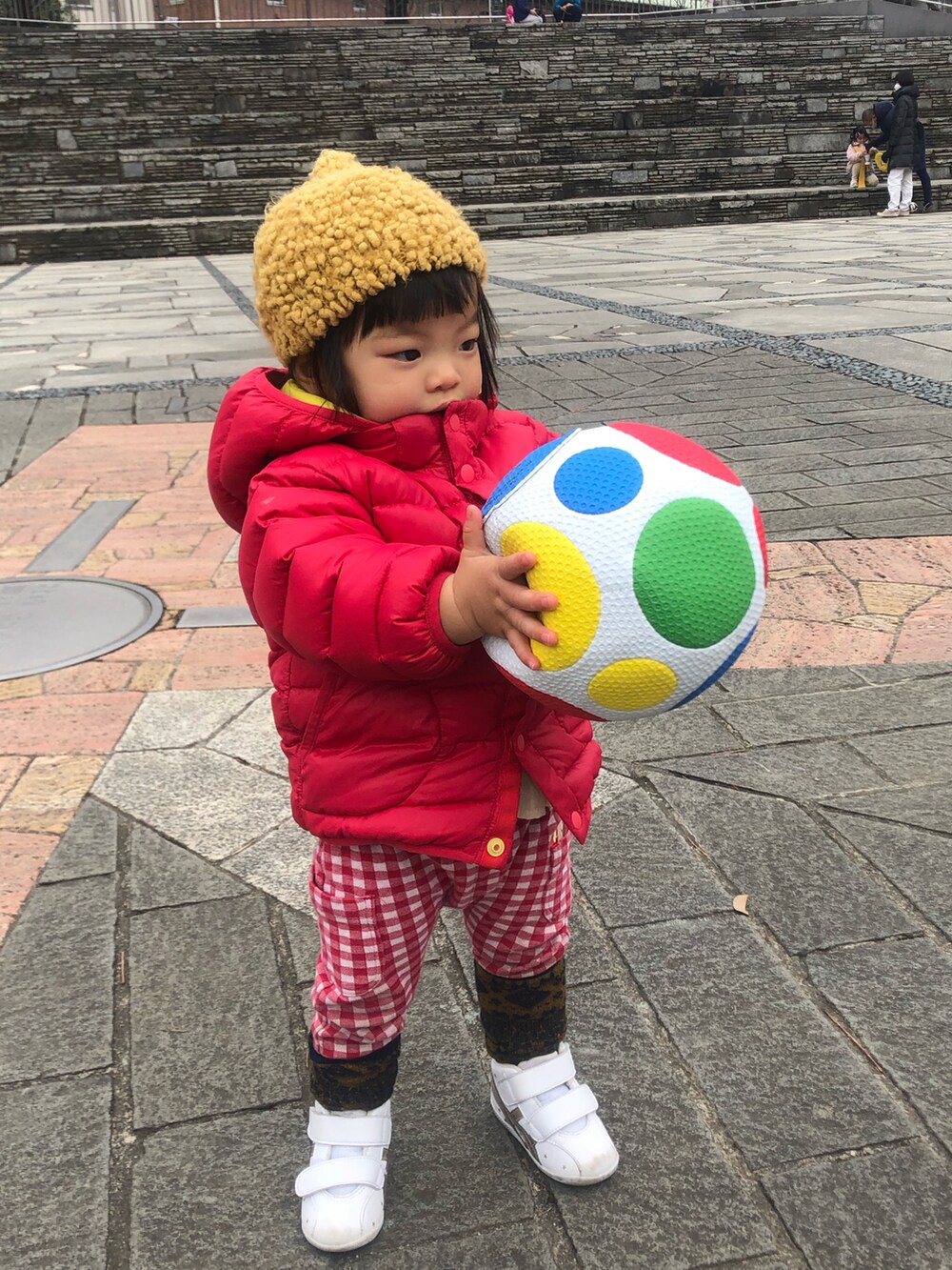 レッド系のダウンジャケット/コート、レッド系のパンツ、ホワイト系のスニーカーを着用したレディースの冬コーディネートの3枚目の写真