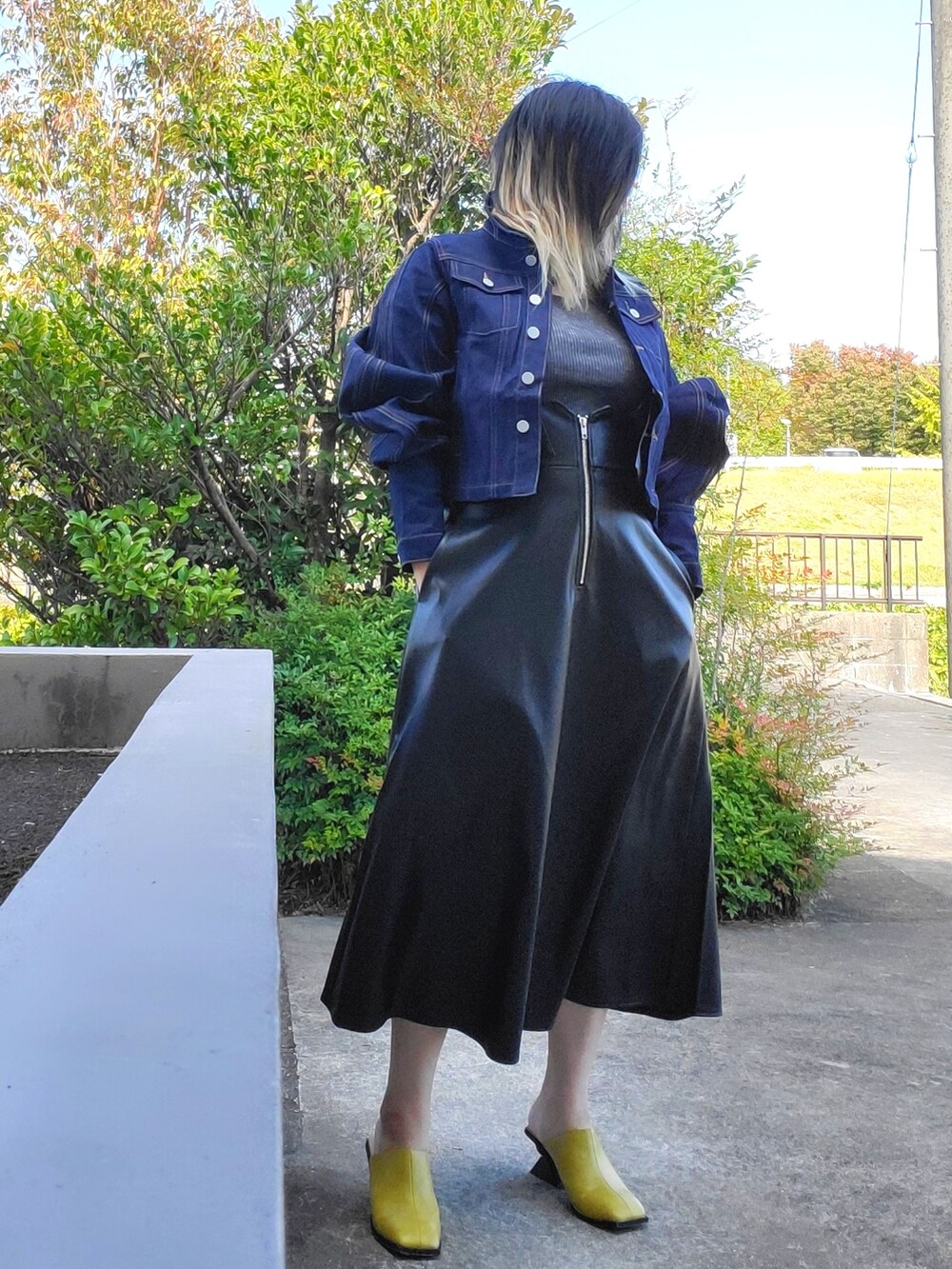 イエロー系のサンダル、ブラック系のワンピース、ブルー系のデニムジャケットを着用したレディースの秋コーディネートの3枚目の写真