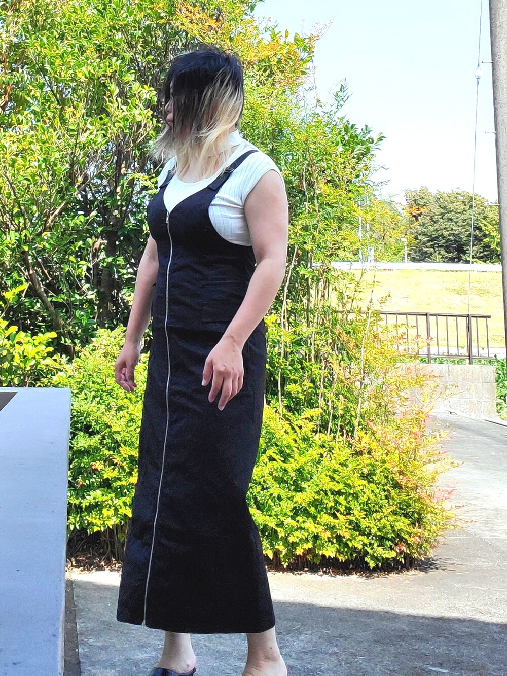 ブラック系のジャンパースカート、ホワイト系のニット/セーター、ブラック系のパンプスを着用したレディースの秋コーディネートの5枚目の写真