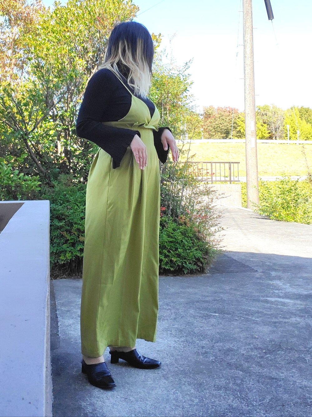 ブラック系のパンプス、ブラック系のニット/セーター、グリーン系のサロペット/オーバーオールを着用したレディースの秋コーディネートの3枚目の写真