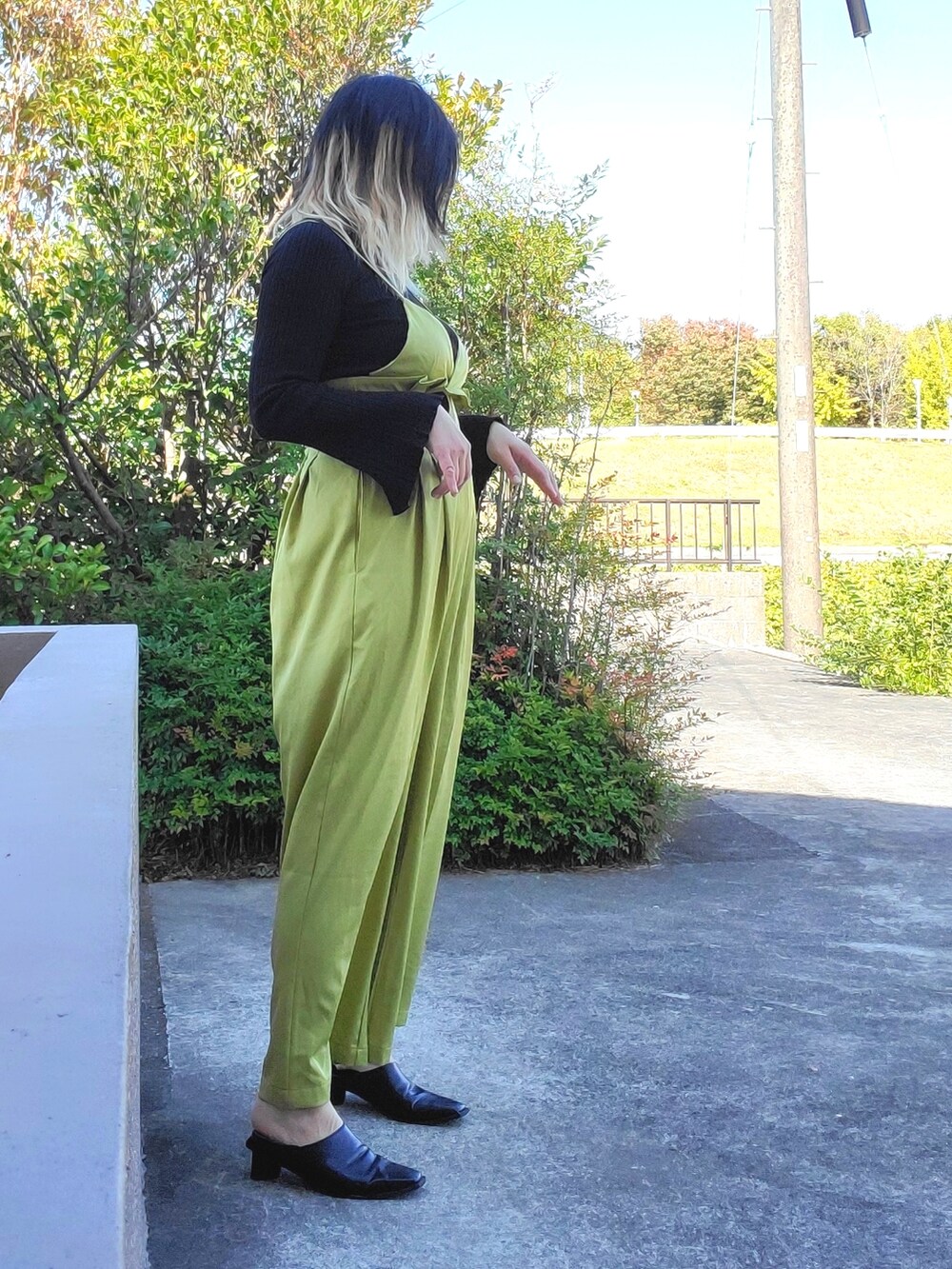 ブラック系のパンプス、ブラック系のニット/セーター、グリーン系のサロペット/オーバーオールを着用したレディースの秋コーディネートの2枚目の写真