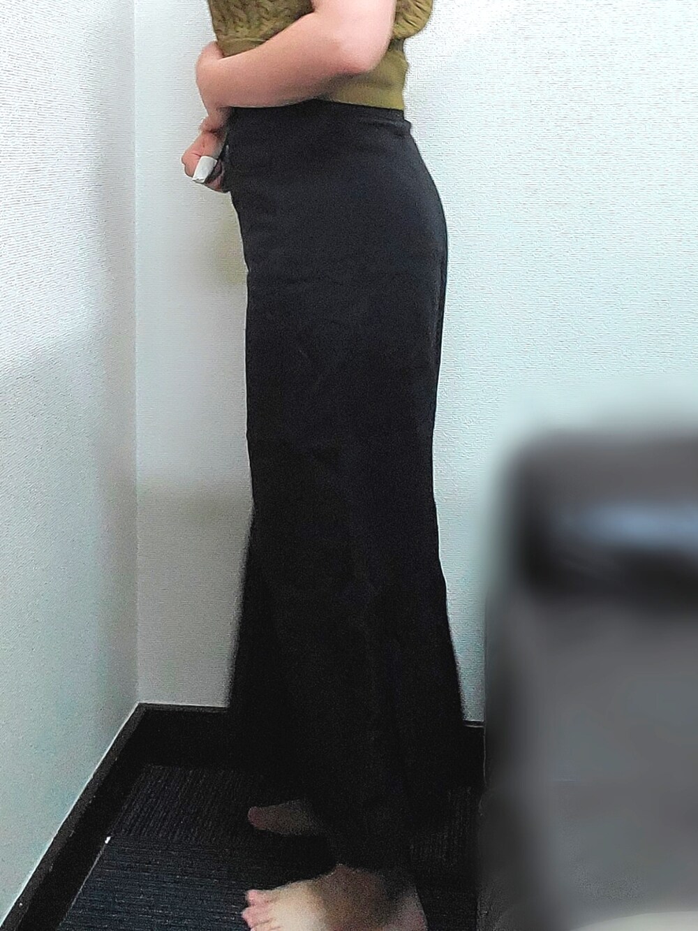 イエロー系のニット/セーター、ブラック系のデニムスカートを着用したレディースの秋コーディネートの5枚目の写真