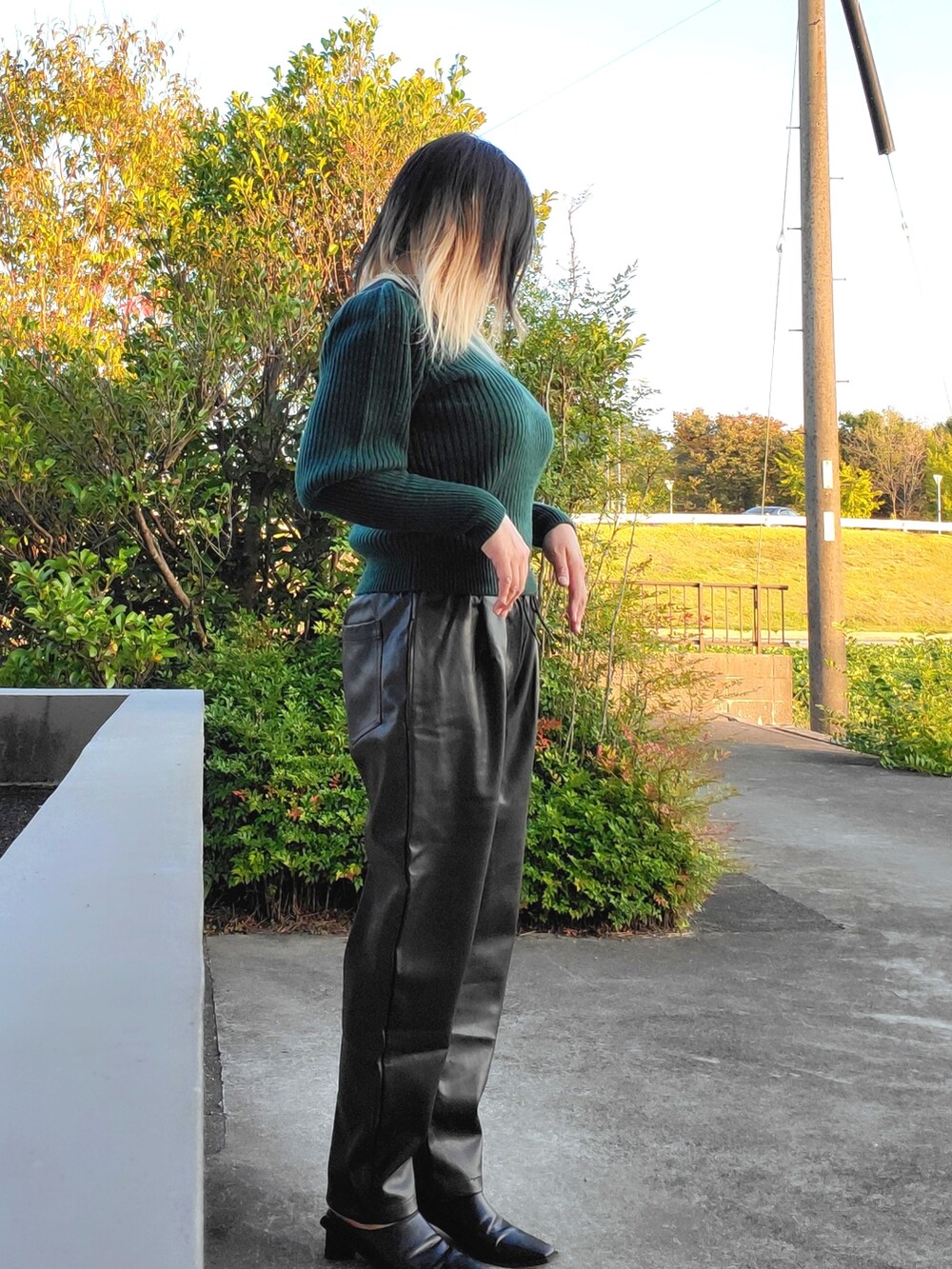 グレー系のその他パンツ、ブラック系のパンプス、グリーン系のニット/セーターを着用したレディースの秋コーディネートの3枚目の写真