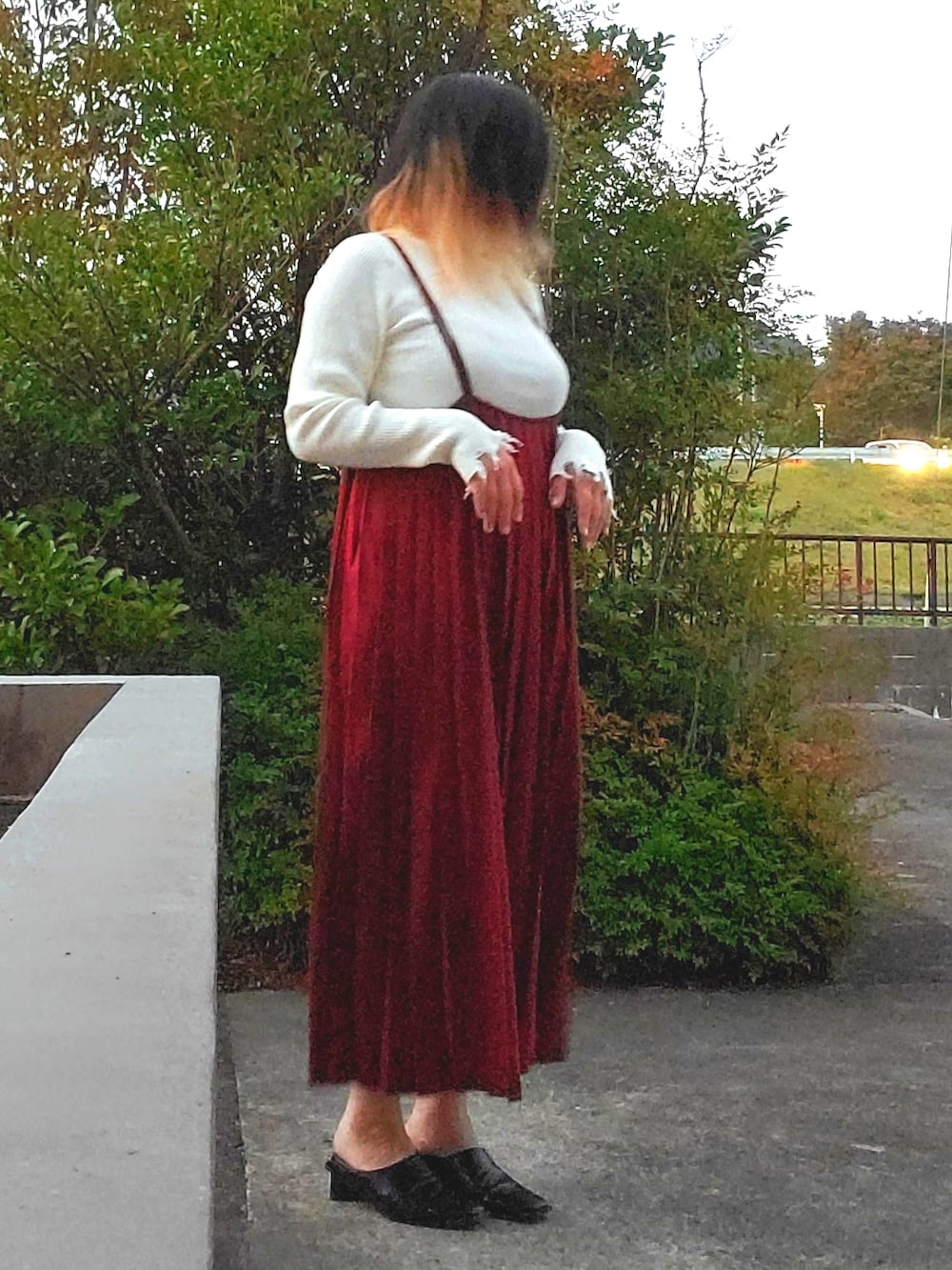 ブラック系のパンプス、レッド系のワンピース、ホワイト系のニット/セーターを着用したレディースの秋コーディネートの3枚目の写真