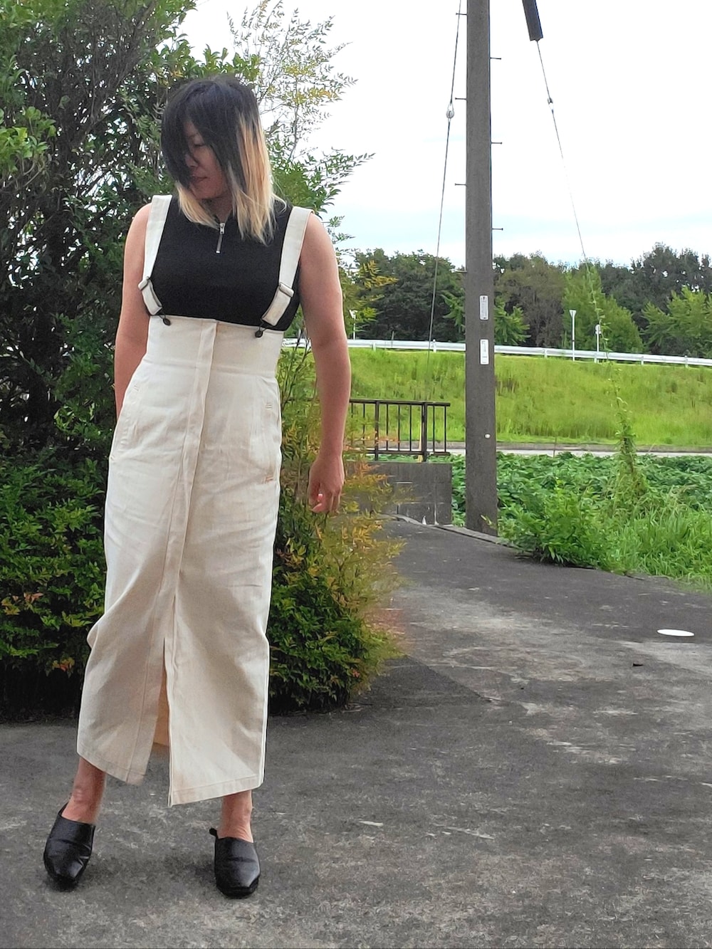 ブラック系のタンクトップ、ブラック系のパンプス、ブラック系のスカートを着用したレディースの秋コーディネートの3枚目の写真