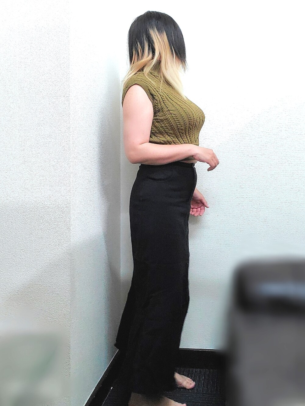 イエロー系のニット/セーター、ブラック系のデニムスカートを着用したレディースの秋コーディネートの3枚目の写真