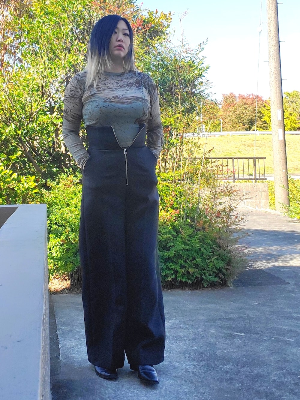 ブラック系のその他パンツ、ブラック系のパンプス、グリーン系のTシャツ/カットソーを着用したレディースの秋コーディネートの4枚目の写真