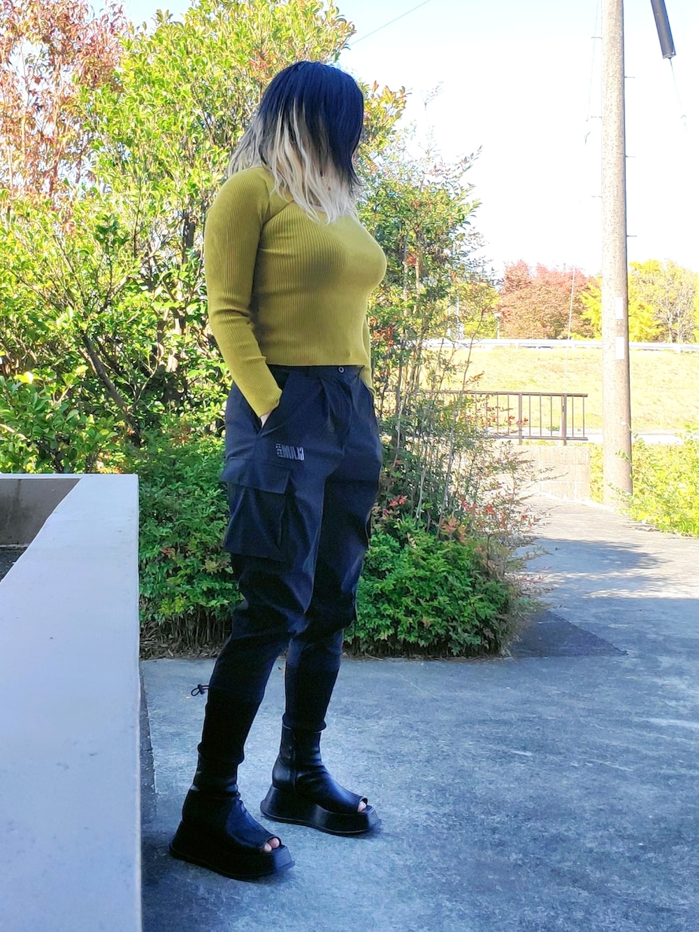 ブラック系のカーゴパンツ、ブラック系のスリッポン、ブルー系のニット/セーターを着用したレディースの秋コーディネートの4枚目の写真