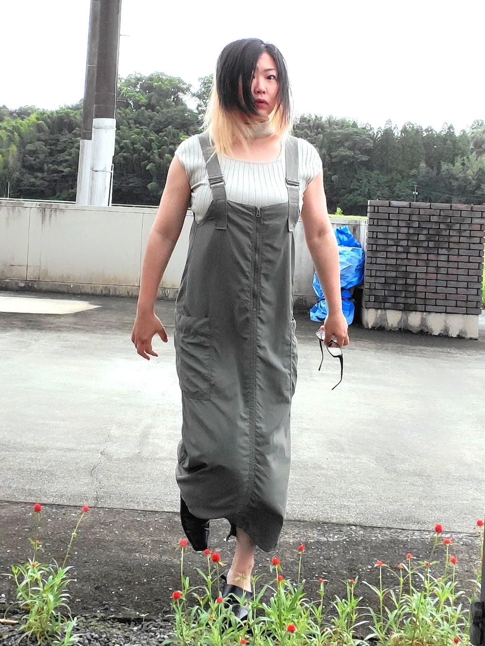 グリーン系のジャンパースカート、ベージュ系のニット/セーター、ブラック系のパンプスを着用したレディースの秋コーディネートの5枚目の写真