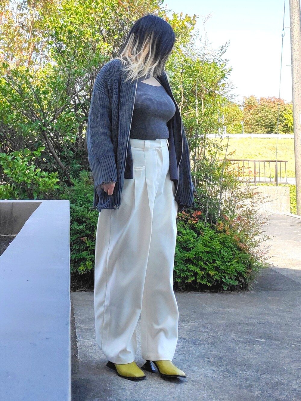 イエロー系のサンダル、ホワイト系のその他パンツ、ブラック系のカーディガン/ボレロを着用したレディースの秋コーディネートの2枚目の写真