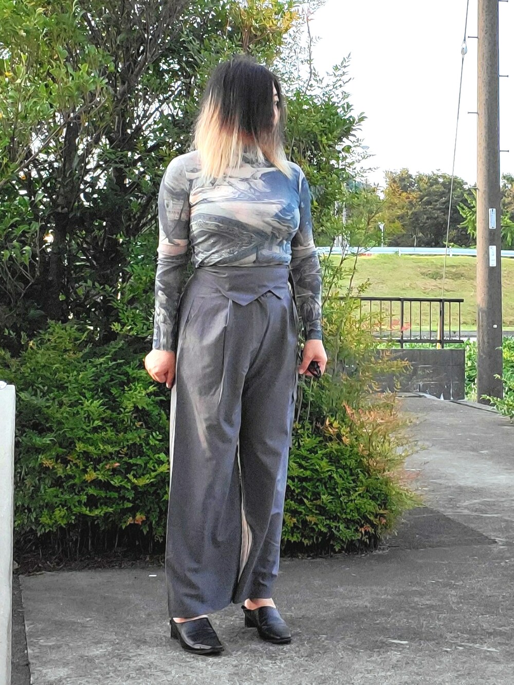 グレー系のその他パンツ、ブラック系のパンプス、ブルー系のTシャツ/カットソーを着用したレディースの秋コーディネートの5枚目の写真