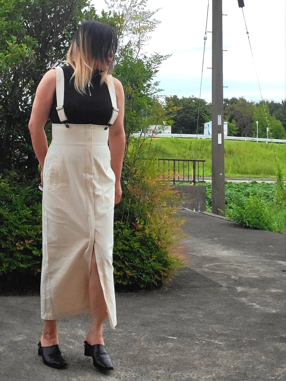 ブラック系のタンクトップ、ブラック系のパンプス、ブラック系のスカートを着用したレディースの秋コーディネートの2枚目の写真