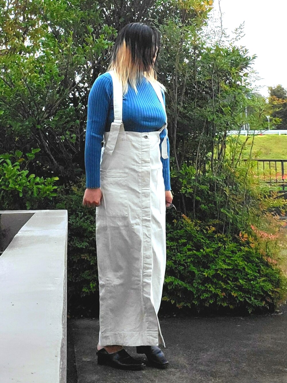 ブラック系のパンプス、ホワイト系のジャンパースカート、ブルー系のニット/セーターを着用したレディースの秋コーディネートの2枚目の写真