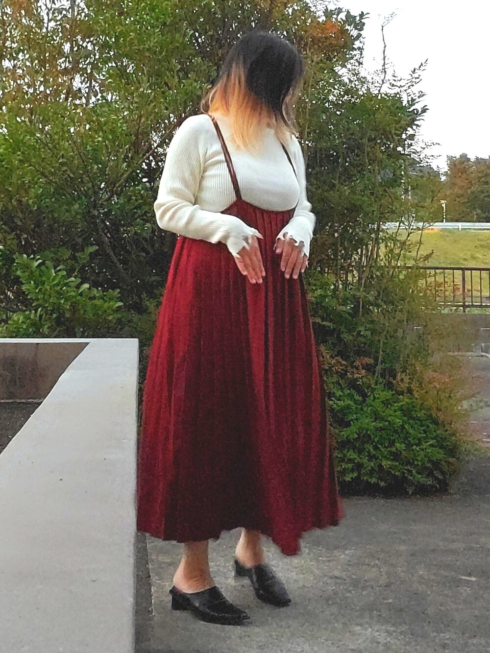 ブラック系のパンプス、レッド系のワンピース、ホワイト系のニット/セーターを着用したレディースの秋コーディネートの2枚目の写真