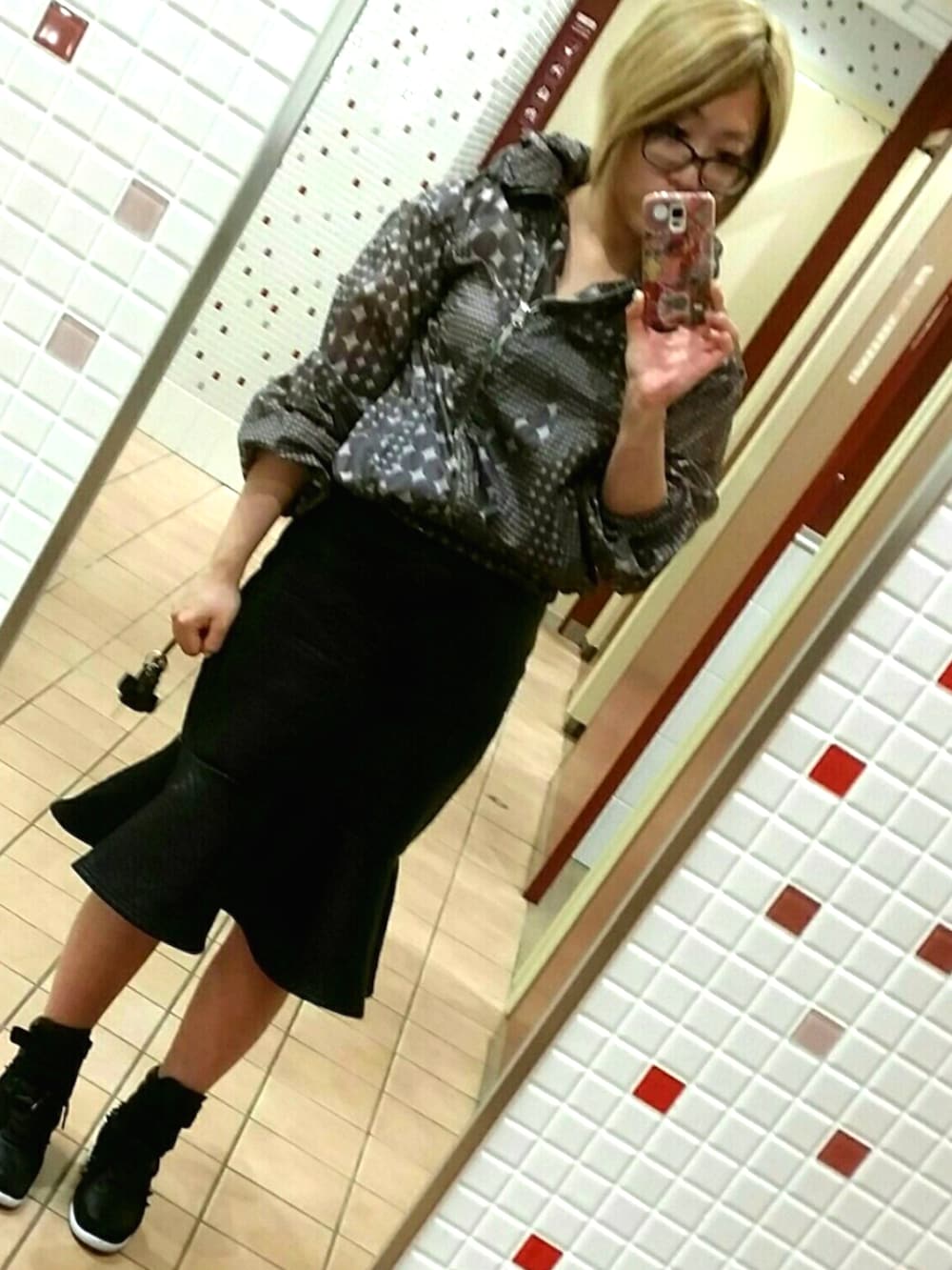 グレー系のナイロンジャケット、ブラック系のスカート、ブラック系のスニーカーを着用したレディースの夏コーディネートの2枚目の写真