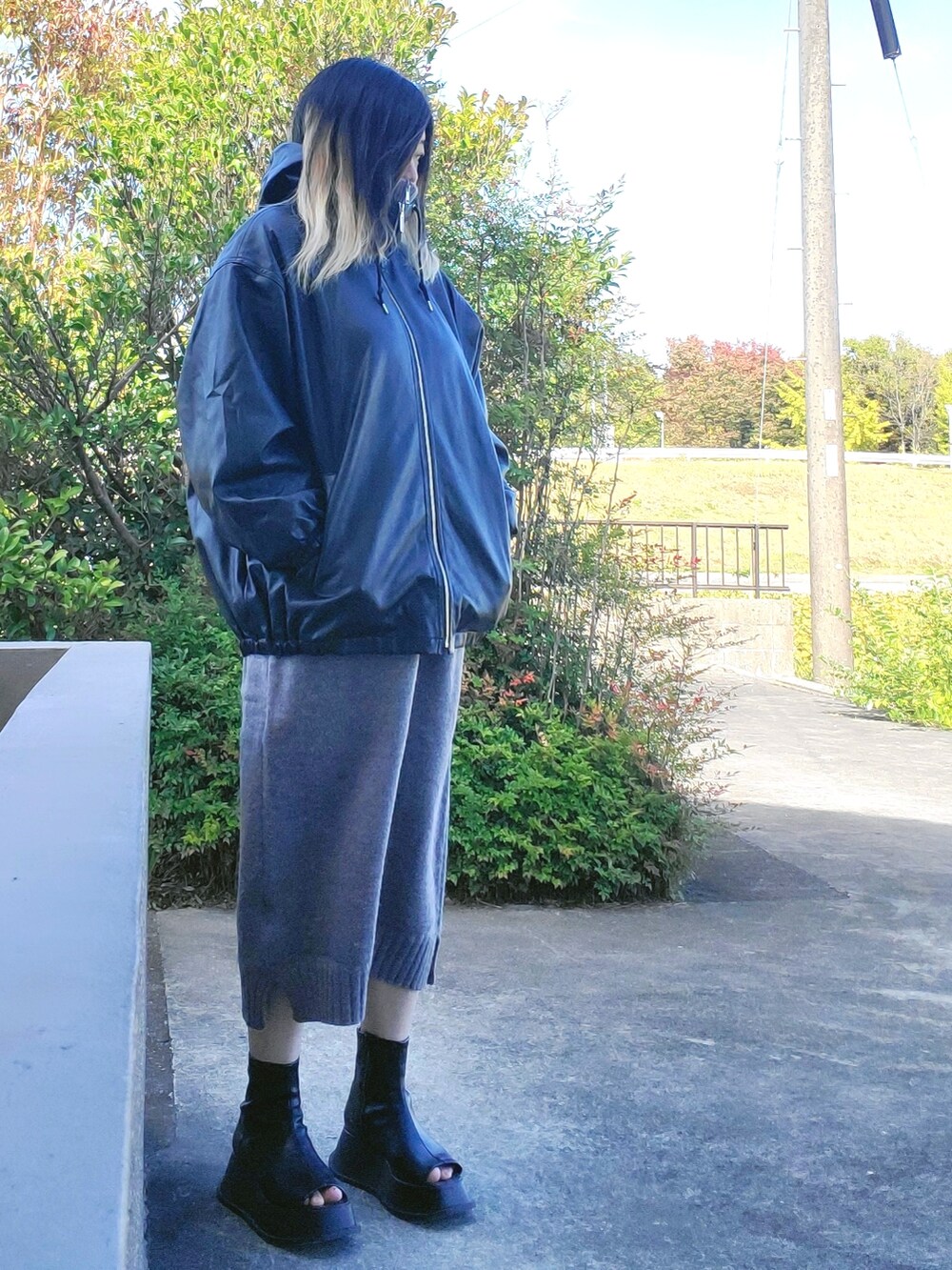 ブラック系のジャケット/アウター、グレー系のワンピース、ブラック系のスリッポンを着用したレディースの秋コーディネートの2枚目の写真