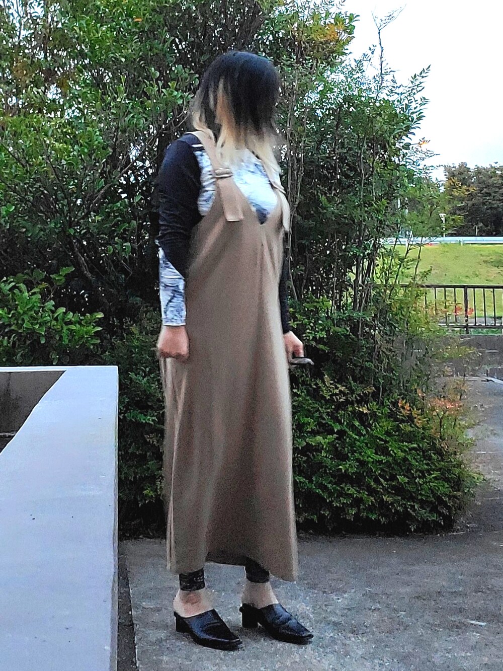 ブラック系のパンプス、ベージュ系のジャンパースカート、ホワイト系のTシャツ/カットソーを着用したレディースの秋コーディネートの3枚目の写真