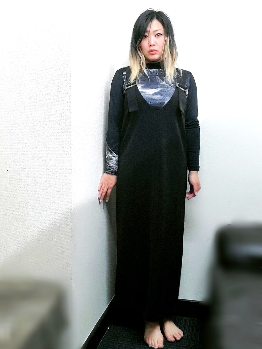 ブラック系のジャンパースカート、ホワイト系のTシャツ/カットソーを着用したレディースの秋コーディネートの2枚目の写真