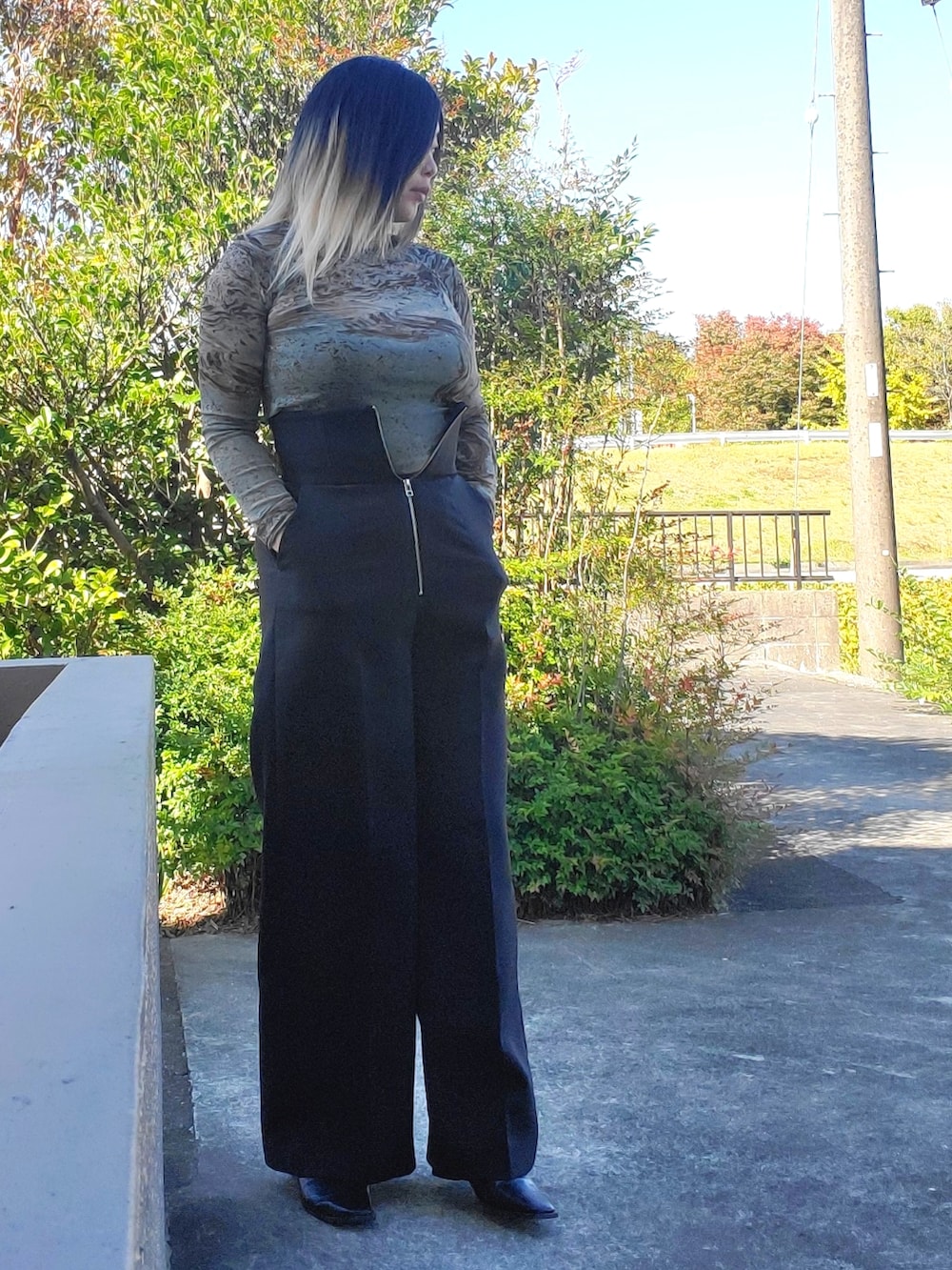 ブラック系のその他パンツ、ブラック系のパンプス、グリーン系のTシャツ/カットソーを着用したレディースの秋コーディネートの3枚目の写真