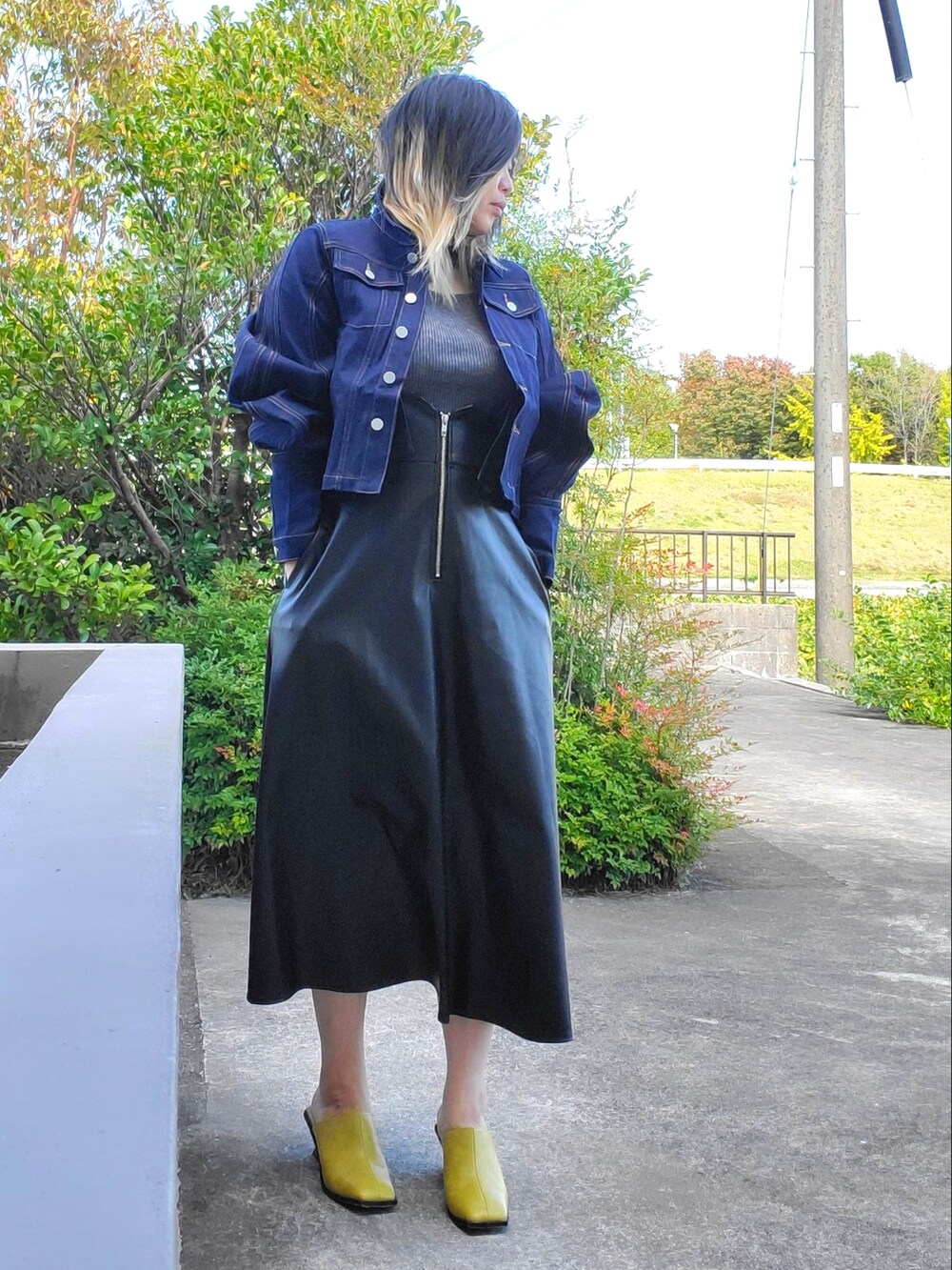 イエロー系のサンダル、ブラック系のワンピース、ブルー系のデニムジャケットを着用したレディースの秋コーディネートの4枚目の写真