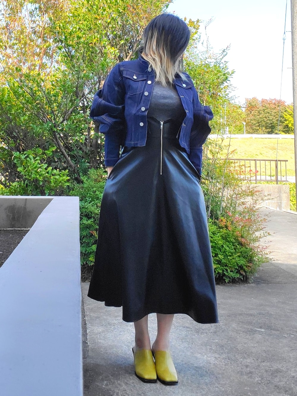 イエロー系のサンダル、ブラック系のワンピース、ブルー系のデニムジャケットを着用したレディースの秋コーディネートの2枚目の写真