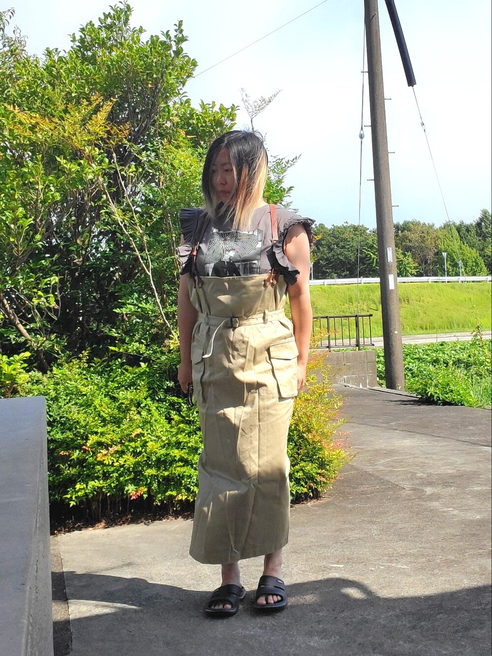 ブラック系のTシャツ/カットソー、ベージュ系のサロペット/オーバーオールを着用したレディースの夏コーディネートの5枚目の写真