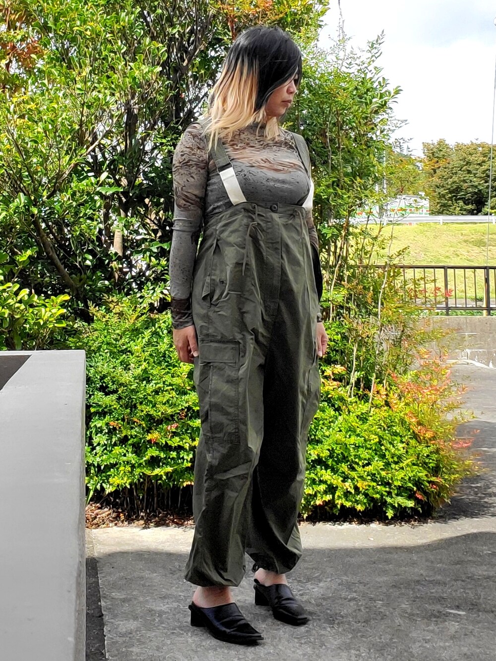 ブルー系のその他パンツ、ブラック系のパンプス、グリーン系のTシャツ/カットソーを着用したレディースの秋コーディネートの2枚目の写真