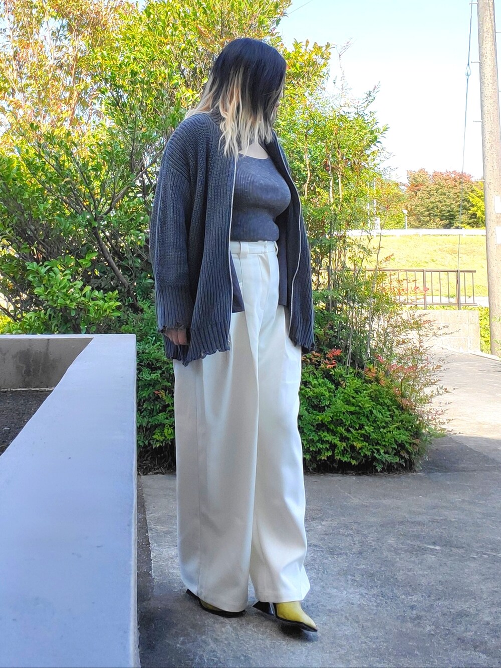 イエロー系のサンダル、ホワイト系のその他パンツ、ブラック系のカーディガン/ボレロを着用したレディースの秋コーディネートの3枚目の写真