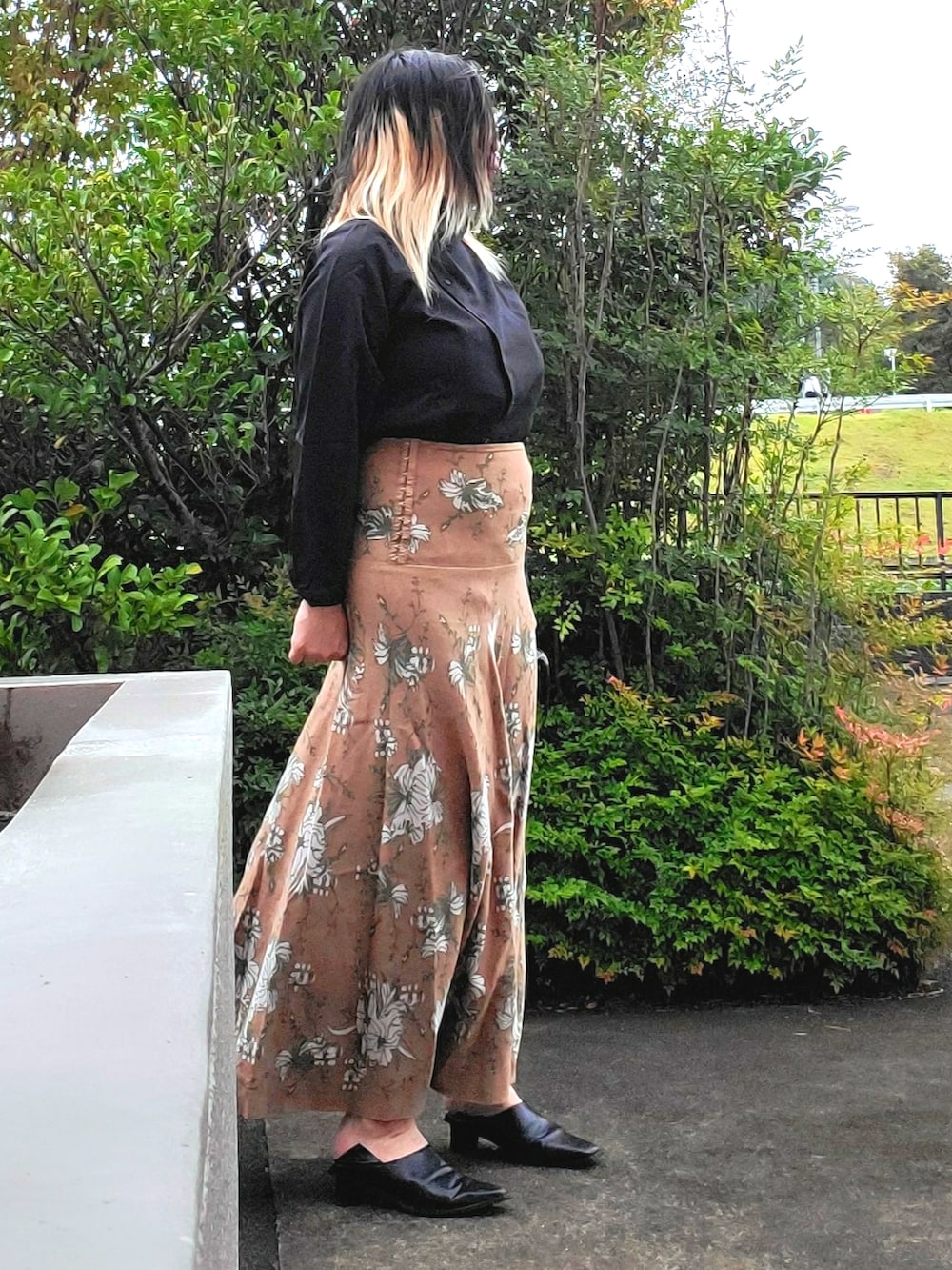 ブラック系のシャツ/ブラウス、ベージュ系のスカート、ブラック系のパンプスを着用したレディースの秋コーディネートの2枚目の写真