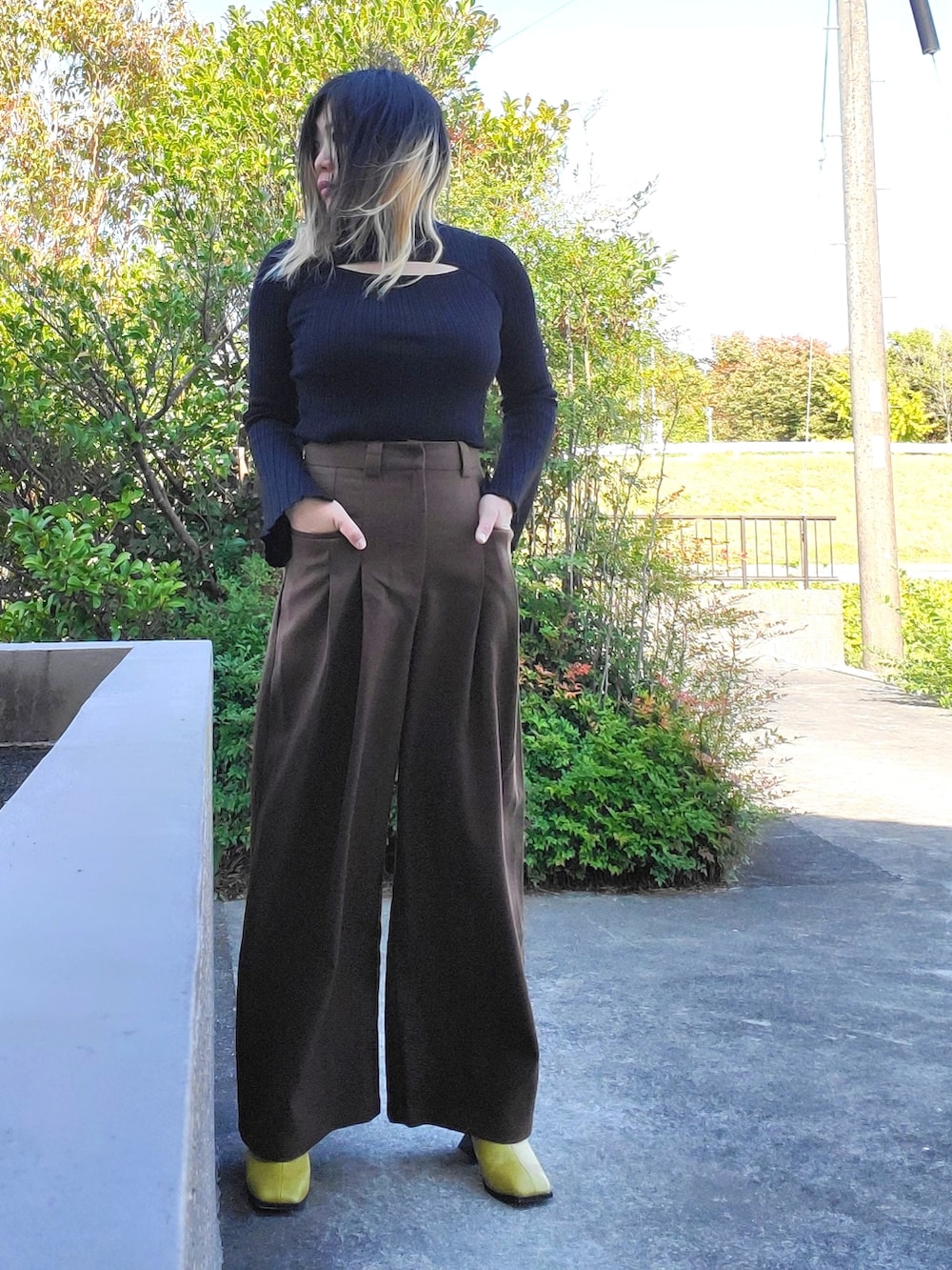 イエロー系のサンダル、ブラウン系のその他パンツ、ブラック系のニット/セーターを着用したレディースの秋コーディネートの4枚目の写真