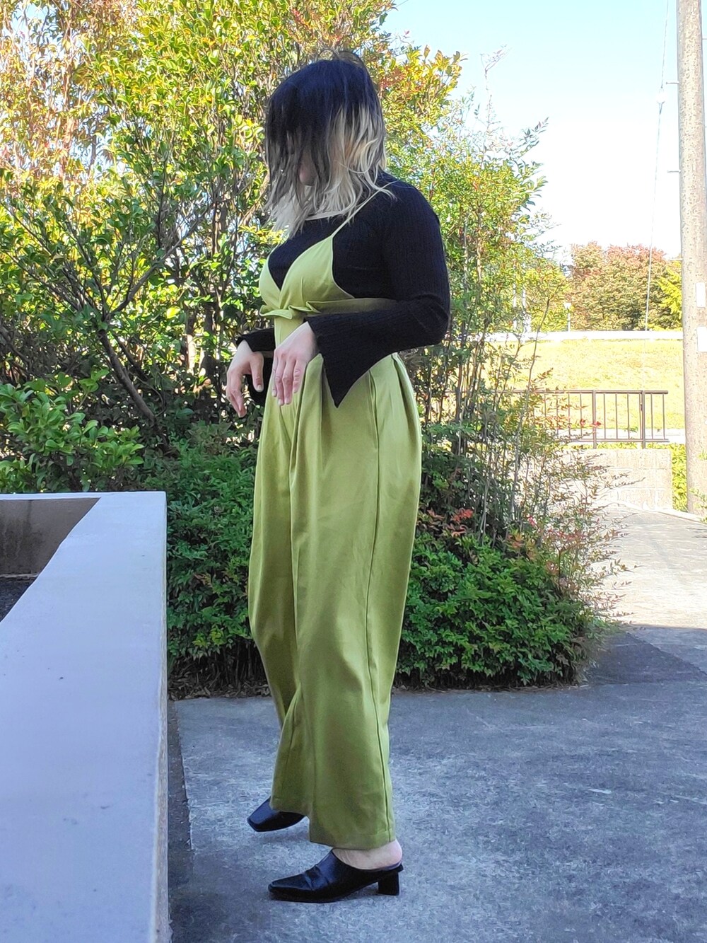 ブラック系のパンプス、ブラック系のニット/セーター、グリーン系のサロペット/オーバーオールを着用したレディースの秋コーディネートの4枚目の写真