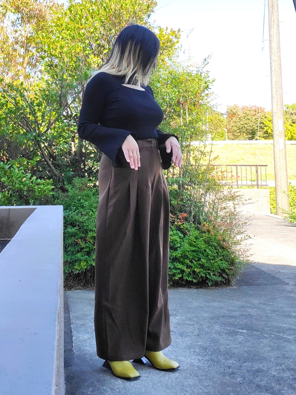 イエロー系のサンダル、ブラウン系のその他パンツ、ブラック系のニット/セーターを着用したレディースの秋コーディネートの3枚目の写真