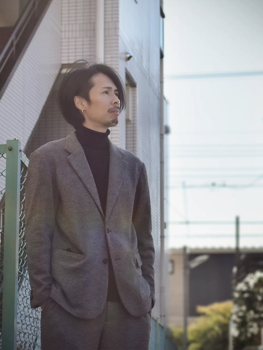 ベージュ系のその他パンツ、ベージュ系のテーラードジャケット、ブラック系のニット/セーターを着用したメンズの冬コーディネートの2枚目の写真